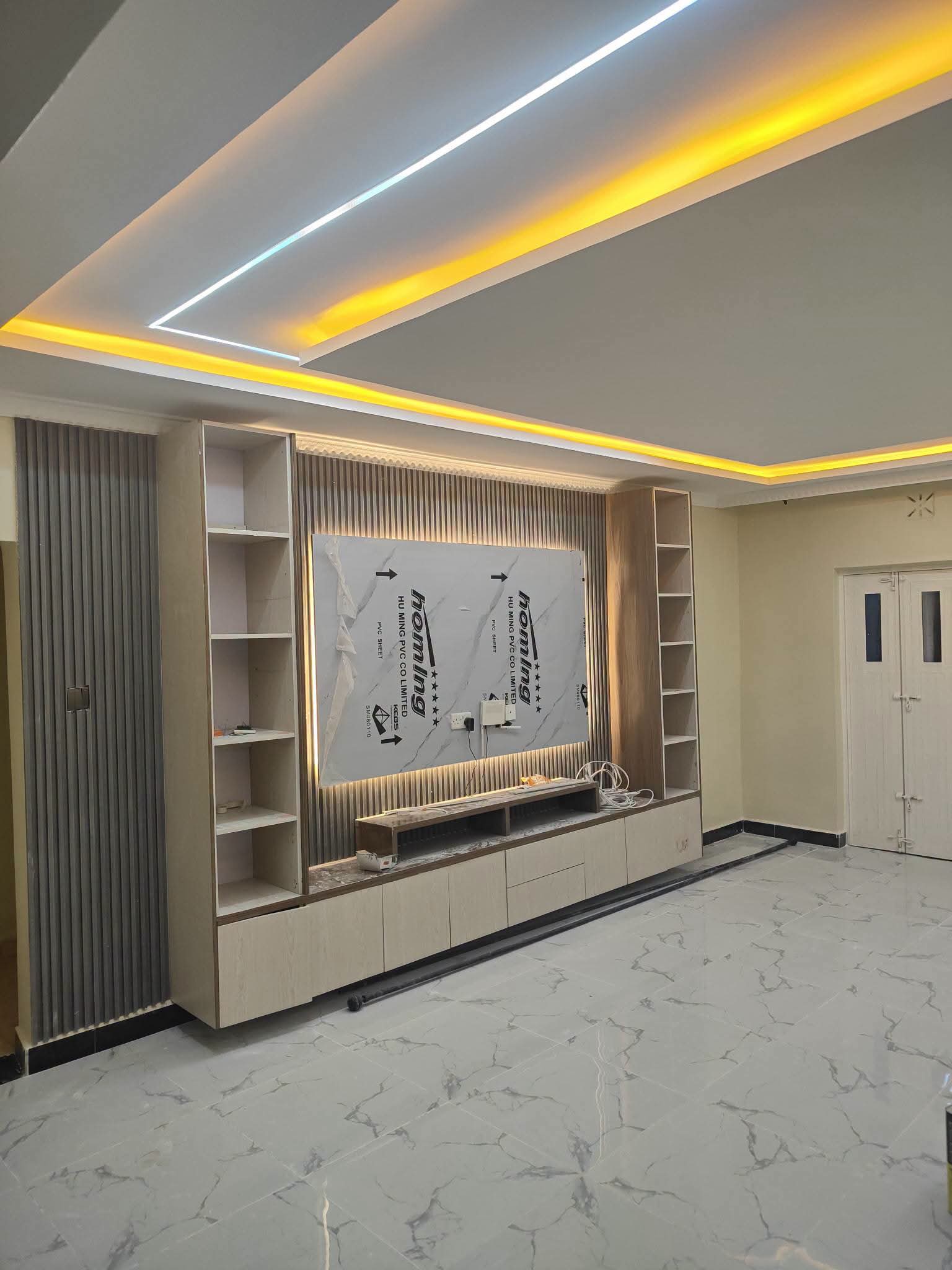 Custom media wall and integrated ceiling lighting during interior fit-out